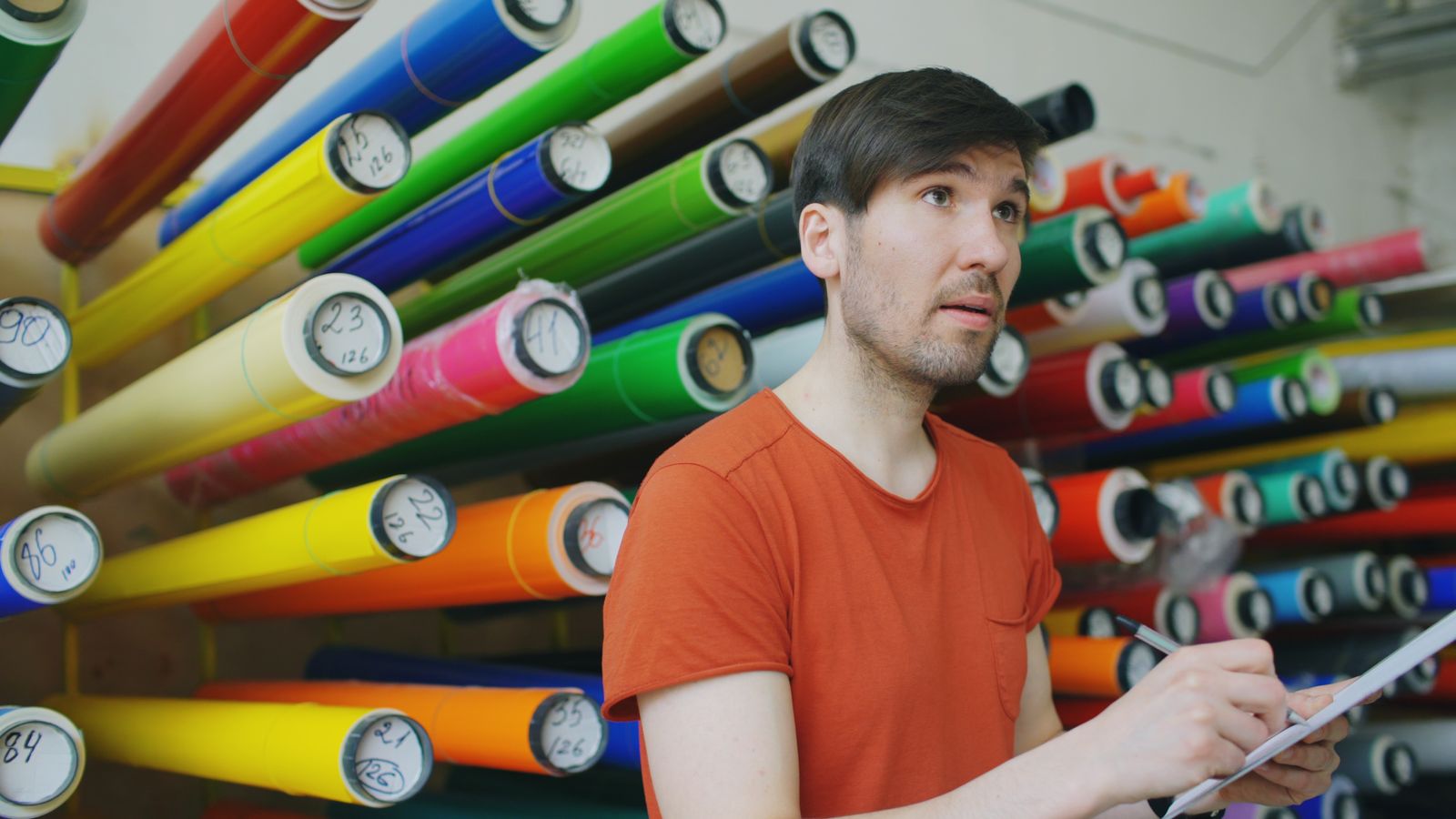 Sign maker checking coloured vinyl in a workshop